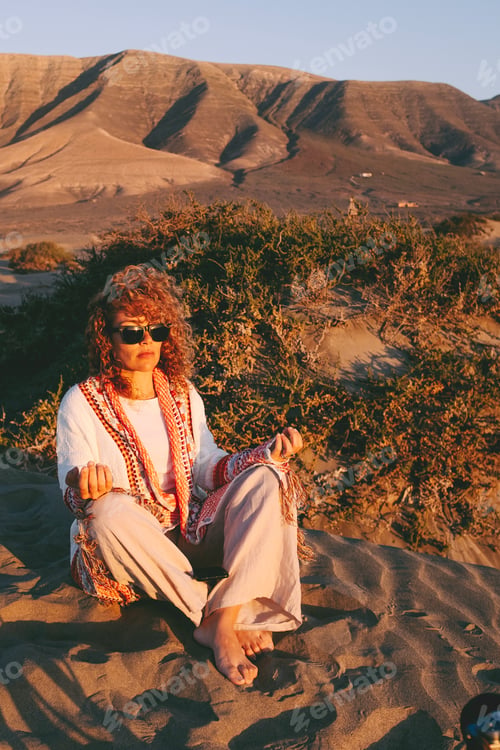Preview: Alternative lifestyle people with attractive woman doing meditation leisure outdoor sitting on sand