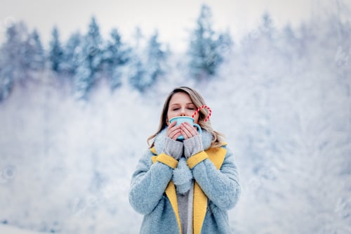 Preview: girl in gray coat with cup in a snow forest