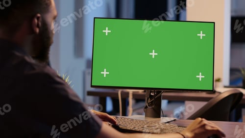 Preview: African american man looking at computer with greenscreen