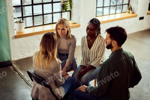 Preview: Group of Four Individuals Engaged in Discussion in a Bright Modern Space