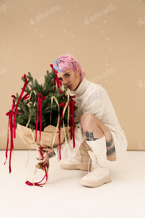 Preview: Festive winter fashion with a beautiful young woman and a decorated holiday tree