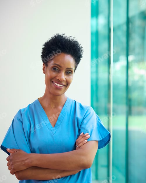 Preview: Portrait Of Mature Smiling Female Doctor Wearing Scrubs In Hospital