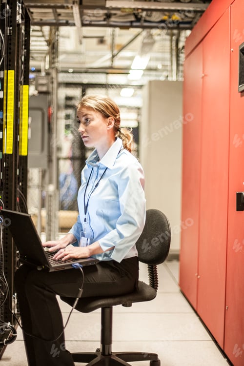 Preview: Caucasian woman technician working on computer servers in a server farm.