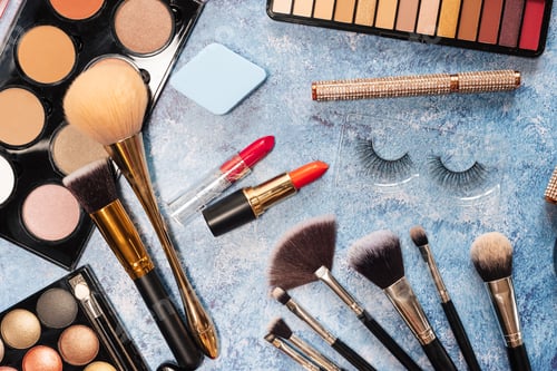 Preview: set of decorative cosmetics, makeup brushes on a blue background. the view from the top