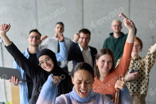 Preview: A diverse team of business professionals ecstatically celebrating their success in a modern office