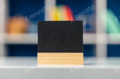 Preview: Little black tag on wooden stand on office table. Copy space for your text