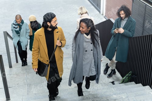 Preview: Black woman and Trendy Young Man talking while going to their workplace in the rush hour