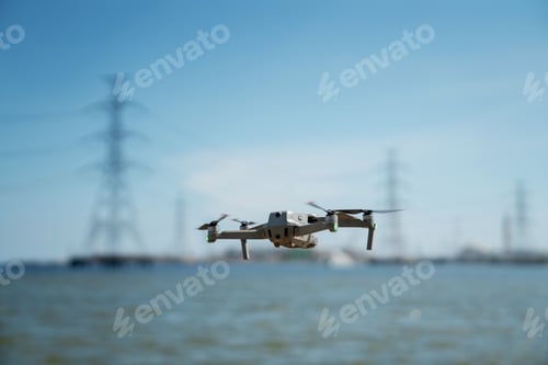 Preview: Engineer in a safety vest operating a drone to inspect and survey electrical power lines.
