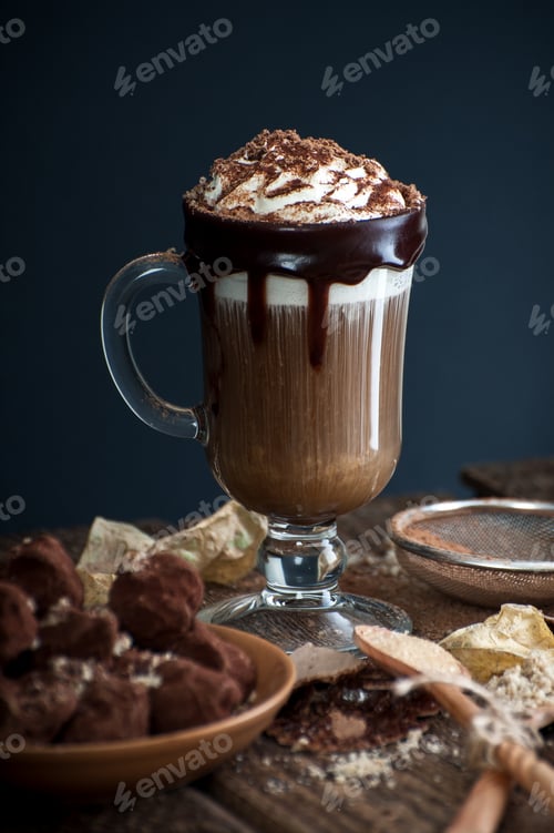 Preview: Coffee with cream and sloppy crumbs on an old wooden table.