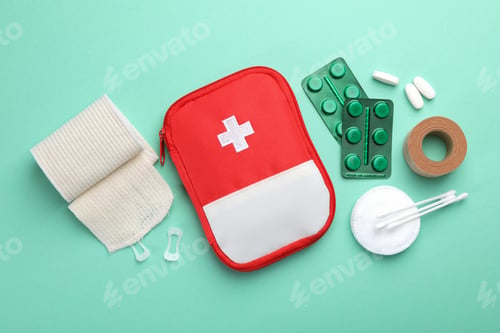 Preview: First aid kit. Different medical supplies on turquoise background, flat lay