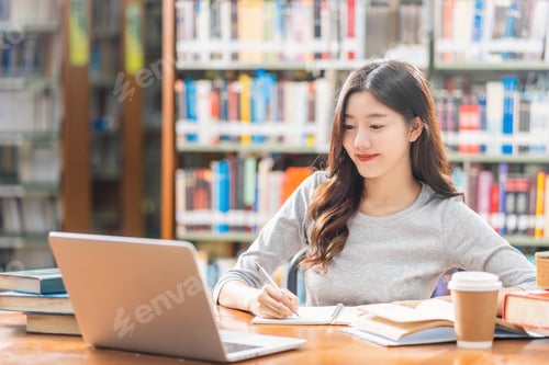 Preview: Asian young Student in casual suit doing homework and using technology laptop