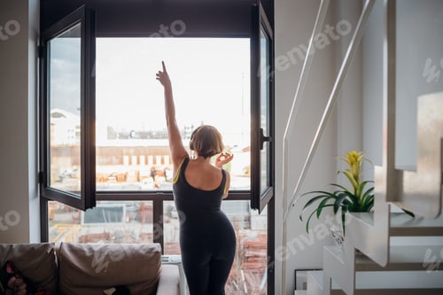 Preview: Adult woman indoor at home dancing open window -free woman enjoying music at home
