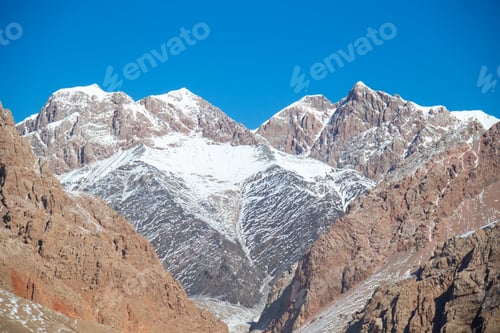 Preview: Majestic snowcapped mountains under a clear blue sky