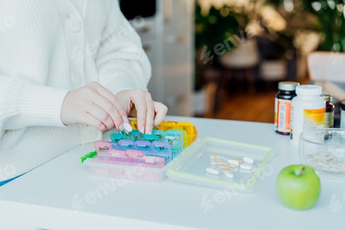 Preview: Woman's hands sorting pills into pills organizer. Close up medical pill box with daily medicines.