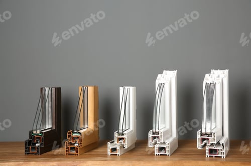 Preview: Samples of modern window profiles on table against gray wall. Installation service