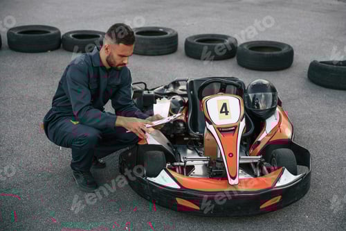 Preview: Mechanic Checking Go-Kart on Asphalt Track