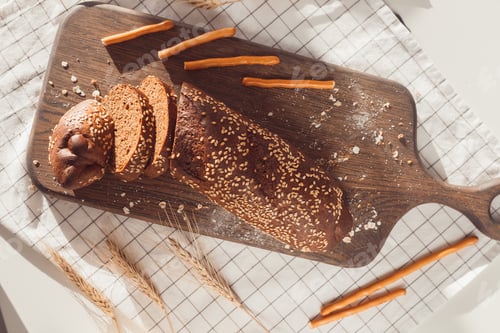 Preview: Sliced rye bread on cutting board. Whole grain rye bread with seeds