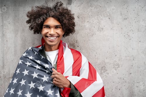 Preview: Smiling young man proudly wrapped in American flag