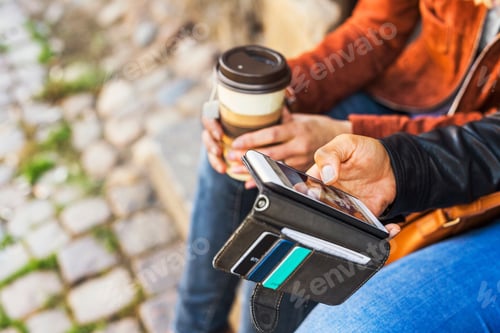 Preview: Women using smart phone and holding cup of coffee