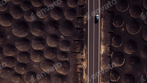 Preview: Lunar landscape concept with long asphalt road and car traveling. Rare holes on the ground