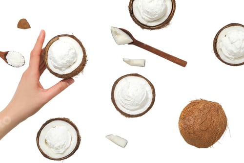 Preview: Coconut shells with smooth dessert inside, on white
