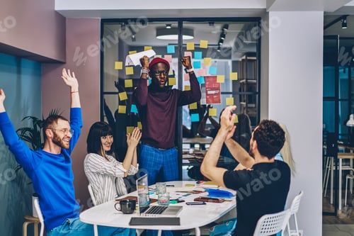 Preview: Cheerful diverse colleagues with raised arms celebrating victory