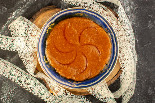 Preview: a top view sweet delicious halva yummy eastern sweet dessert inside plate on the dark background