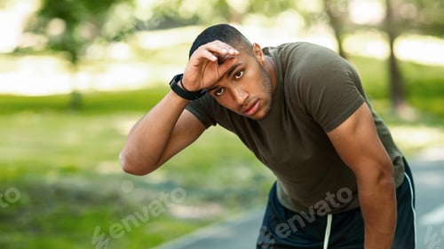 Preview: Athletic black guy feeling tired after his morning run at urban park