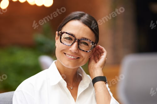 Preview: Portrait of smiling business woman standing on modern office background and looks camera