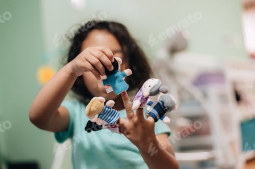 Preview: Diverse Toddler girl playing with finger puppets having fun at home