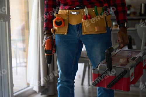 Preview: Male worker in a bright room with tools and a drill