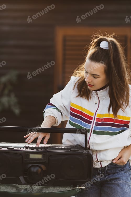 Preview: woman dressed in youth summer clothes listens to music, retro boombox player in her hand