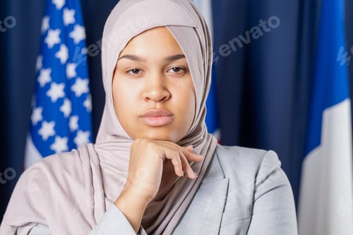 Preview: Young serious female delegate in hijab looking at camera