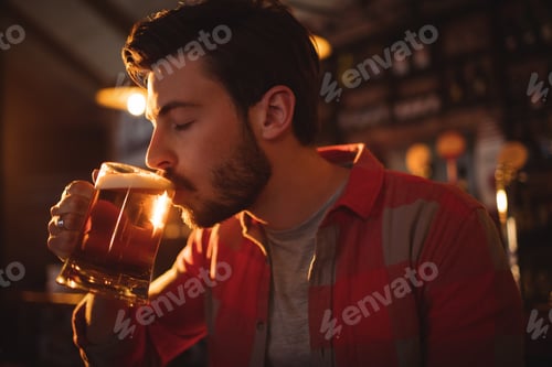 Preview: Young man having mug of beer