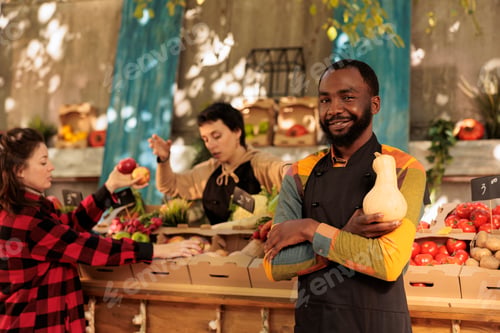 Preview: Happy african american vendor preparing to sell organic food