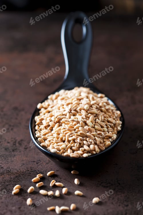 Preview: Spoon of spelt grains on rusty metal
