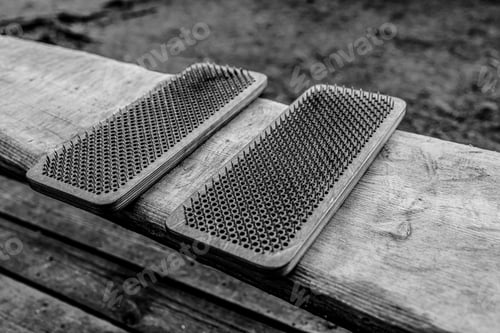 Preview: The woman's feet are next to boards with nails. Yoga outdoors. Nail board. Nature.