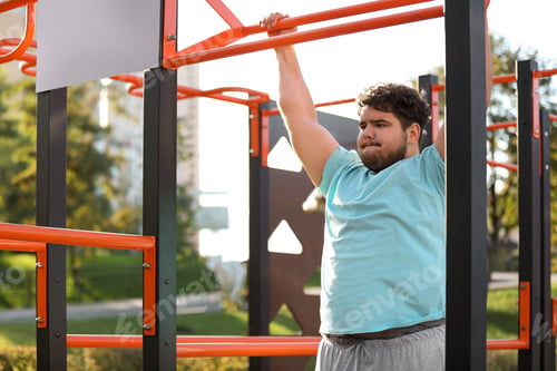 Preview: Young overweight man training on sports ground