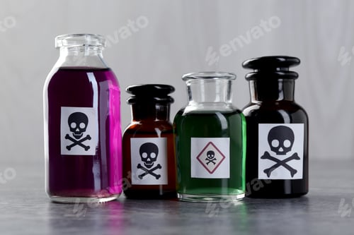 Preview: Bottles of poison with warning sign on gray table
