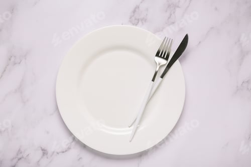 Preview: Clean empty white plate with cutlery.