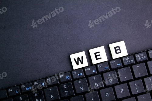Preview: laptop keyboard and alphabet letters with the word website.