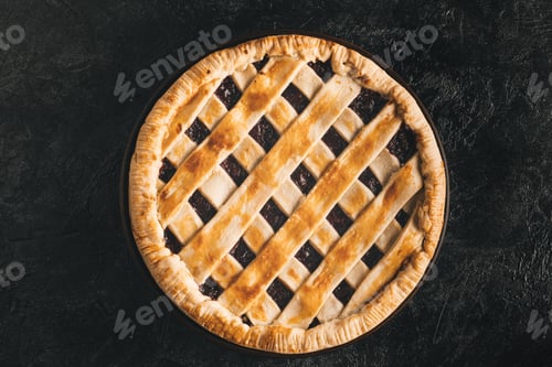 Preview: top view of homemade pie isolated on black tabletop