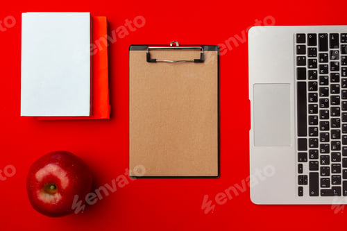 Preview: Top view of student working space with open laptop and red apple