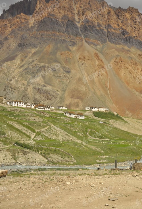 Preview: View of a village next to a beautiful rocky mountain with flowing a river