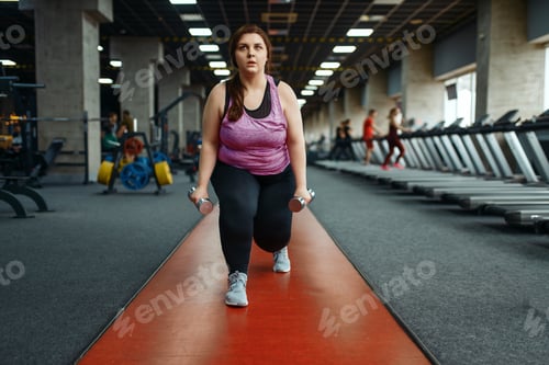 Preview: Overweight woman, exercise with dumbbells in gym