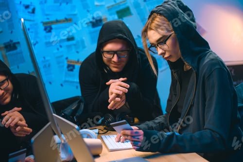 Preview: young couple of hackers with stolen credit card at workplace