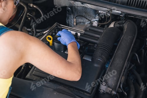 Preview: young brunette girl mechanic fixing a car