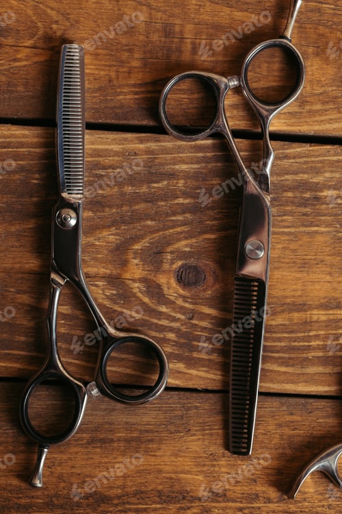 Preview: top view of professional scissors on wooden surface in barbershop