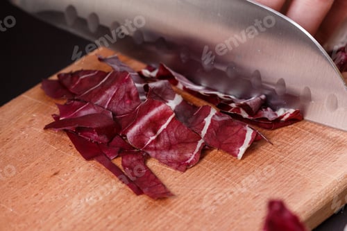 Preview: young woman in a gray aprons cuts radicchio