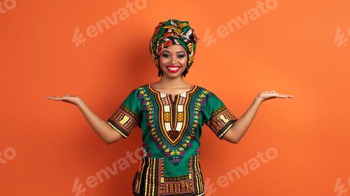 Preview: Pretty traditional african woman holding something on both hands